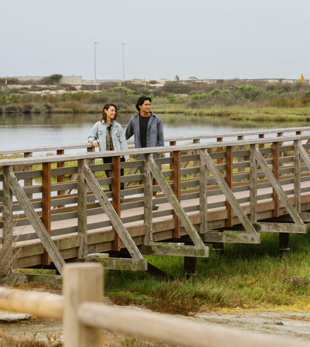 Bolsa Chica Ecological Reserve. Male & Female on a bridge looking out.